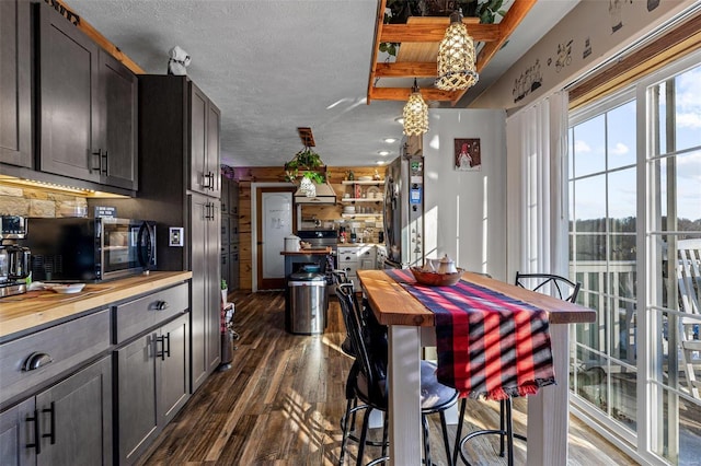 dining area with a textured ceiling and dark hardwood / wood-style floors