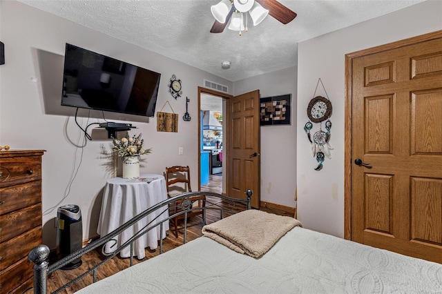 bedroom featuring ceiling fan, a textured ceiling, and hardwood / wood-style flooring