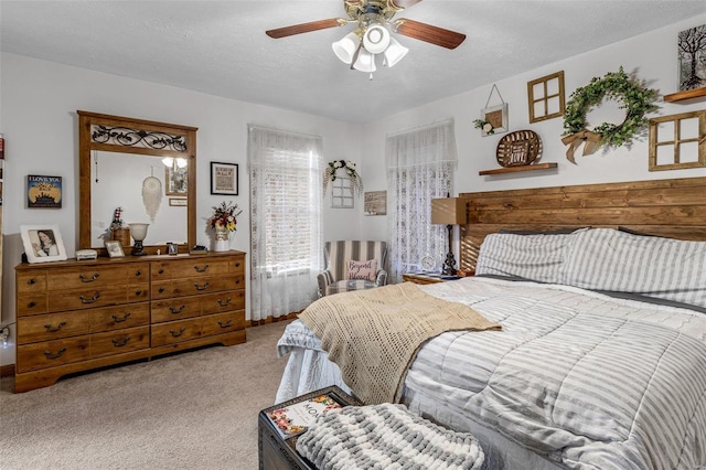 carpeted bedroom with ceiling fan and a textured ceiling