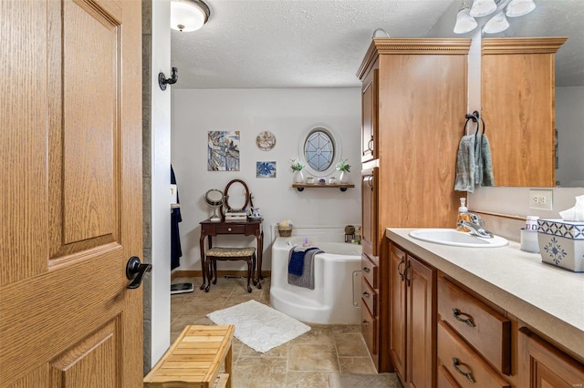 bathroom featuring vanity, a tub, and a textured ceiling