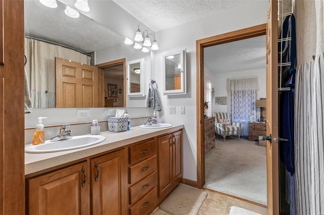 bathroom with a textured ceiling, vanity, and tile patterned flooring