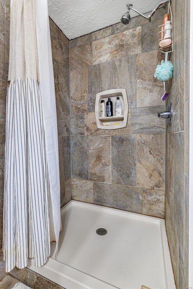 bathroom featuring a shower with curtain and a textured ceiling