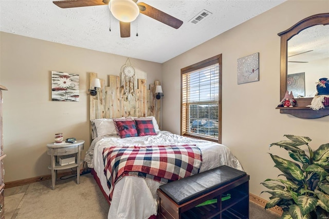 carpeted bedroom with ceiling fan and a textured ceiling