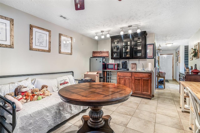 kitchen with rail lighting, a textured ceiling, light tile patterned floors, and sink