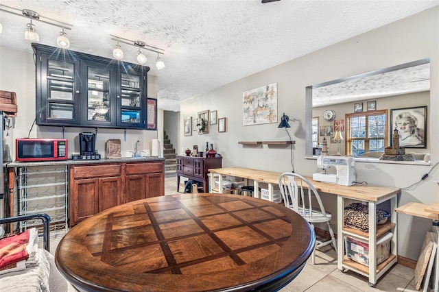 tiled dining area with a textured ceiling