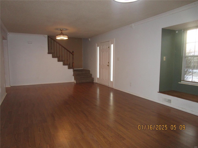 empty room featuring ornamental molding, dark hardwood / wood-style floors, and a textured ceiling