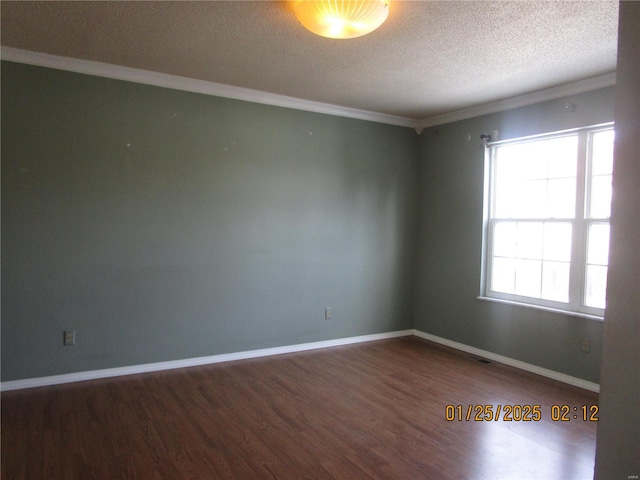 empty room featuring ornamental molding, dark hardwood / wood-style floors, and a textured ceiling