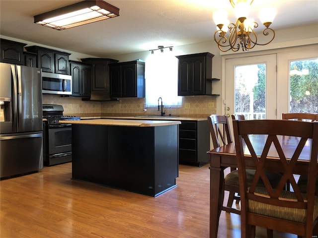 kitchen featuring a center island, appliances with stainless steel finishes, sink, and light hardwood / wood-style flooring