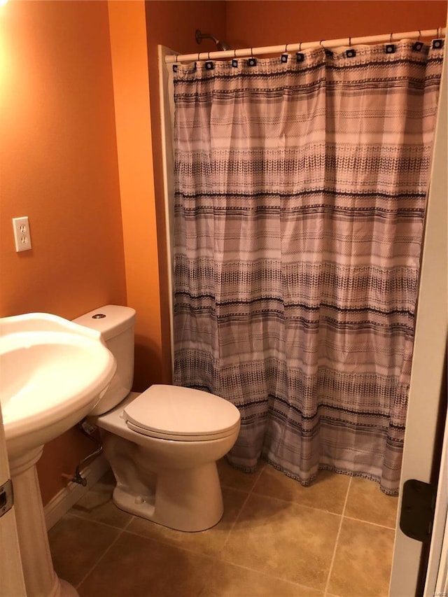 bathroom featuring a shower with curtain, tile patterned floors, and toilet