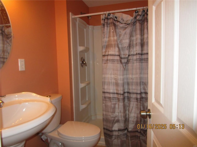 bathroom featuring sink, toilet, and a shower with shower curtain