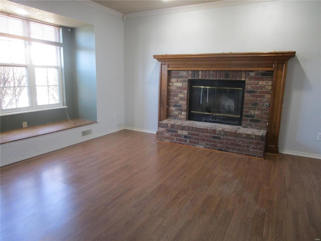 unfurnished living room featuring crown molding, dark wood-type flooring, and a fireplace