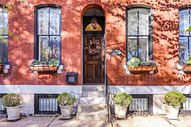 view of exterior entry with brick siding