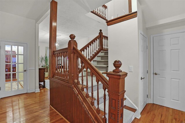 staircase featuring a wealth of natural light, baseboards, and hardwood / wood-style floors