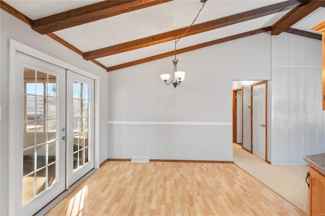 unfurnished dining area featuring a notable chandelier, lofted ceiling with beams, french doors, and light wood-type flooring