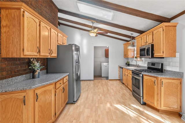 kitchen featuring sink, appliances with stainless steel finishes, vaulted ceiling with beams, tasteful backsplash, and washer / dryer