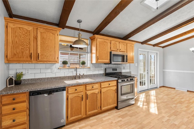 kitchen featuring french doors, sink, tasteful backsplash, appliances with stainless steel finishes, and light hardwood / wood-style floors