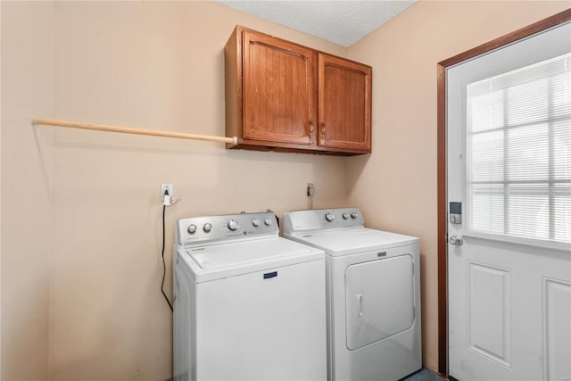 laundry room featuring independent washer and dryer, cabinets, and a textured ceiling