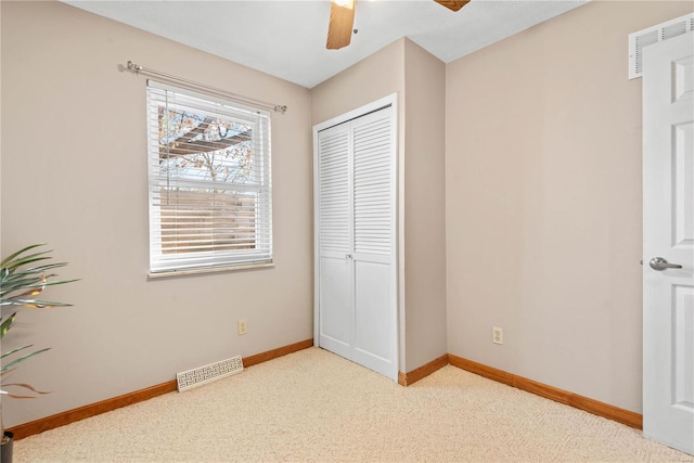 bedroom with light carpet, ceiling fan, and a closet