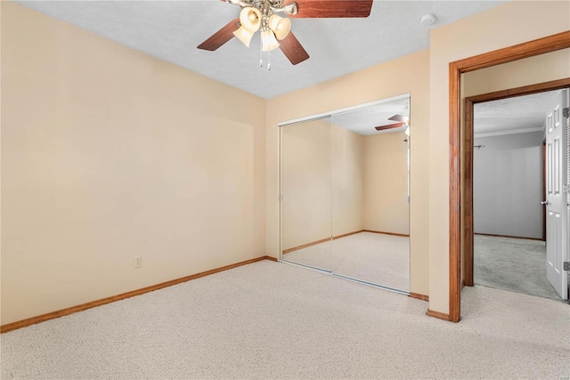 unfurnished bedroom featuring light colored carpet, ceiling fan, and a closet