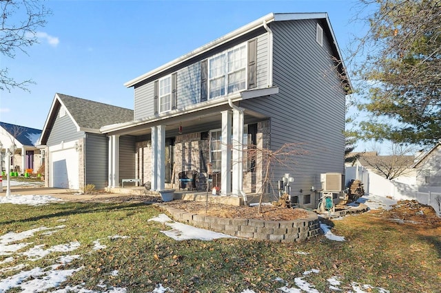 view of front of home with covered porch, a garage, and a front lawn