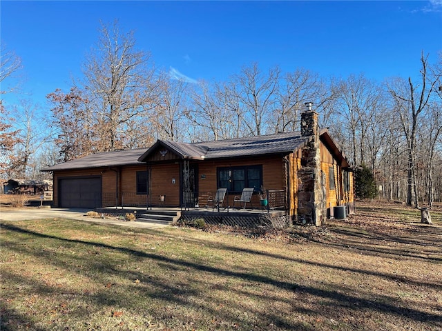 view of front of house featuring a garage, a front yard, and a porch