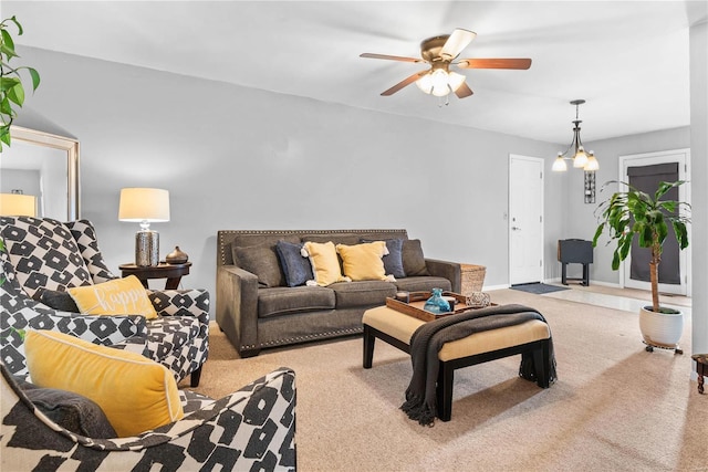 living room featuring ceiling fan with notable chandelier and light colored carpet