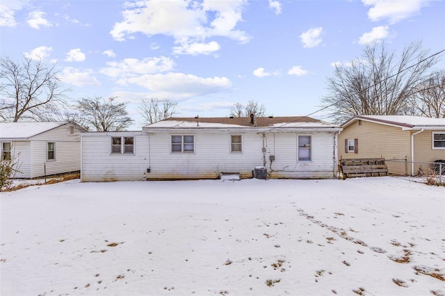 snow covered house featuring central AC unit