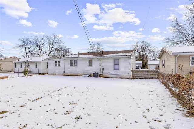 snow covered rear of property with central AC unit