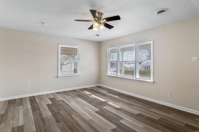 spare room with hardwood / wood-style flooring, a wealth of natural light, and ceiling fan