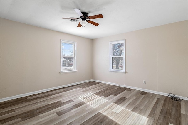 empty room with ceiling fan and light hardwood / wood-style flooring