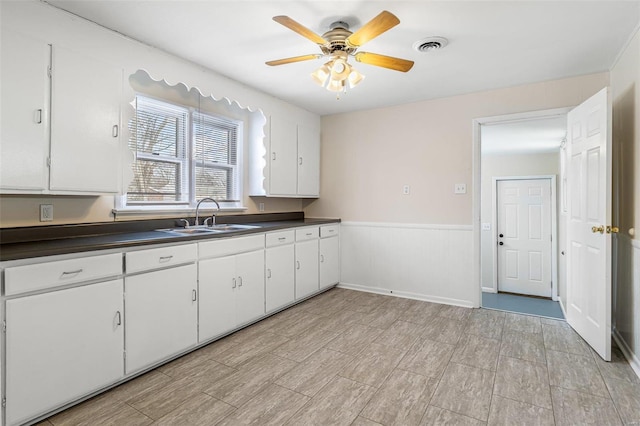 kitchen with sink, white cabinets, and ceiling fan