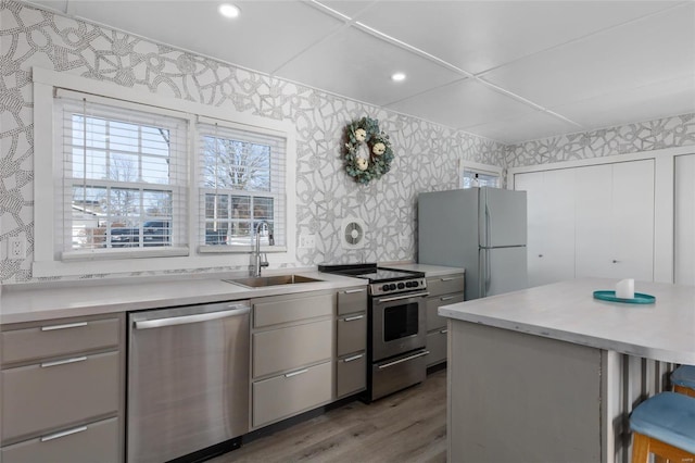 kitchen featuring sink, hardwood / wood-style floors, gray cabinets, and stainless steel appliances