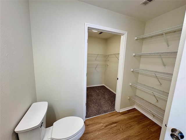 bathroom with toilet and hardwood / wood-style floors