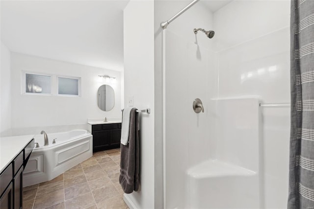 bathroom featuring vanity and independent shower and bath