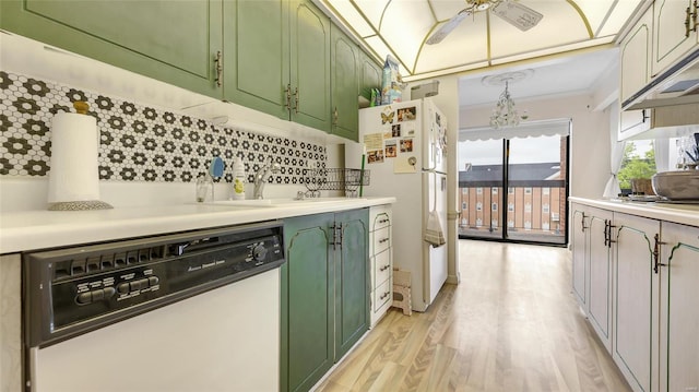 kitchen featuring white appliances, sink, light hardwood / wood-style flooring, and backsplash