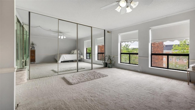 unfurnished bedroom featuring carpet, a textured ceiling, ceiling fan, and a closet