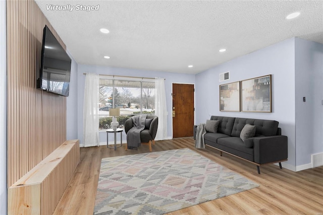 living room featuring light hardwood / wood-style floors and a textured ceiling