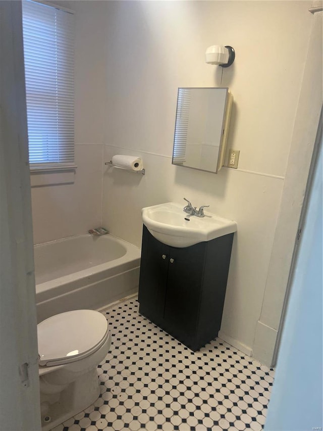 bathroom with toilet, vanity, tile patterned flooring, and a tub