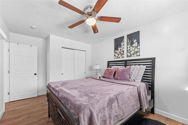 bedroom with hardwood / wood-style floors, a textured ceiling, a closet, and ceiling fan