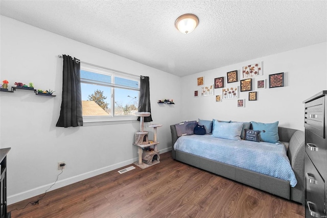 bedroom featuring dark wood-type flooring and a textured ceiling