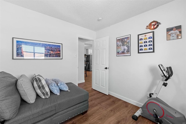 workout room featuring dark hardwood / wood-style flooring and a textured ceiling