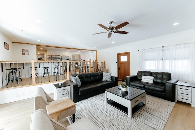 living room featuring ceiling fan, stairway, wood finished floors, and recessed lighting