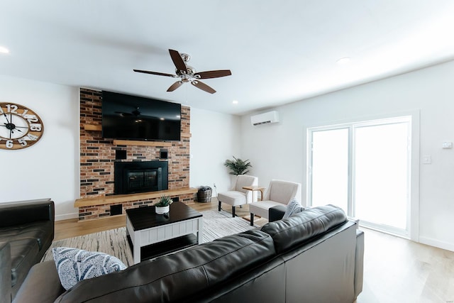 living area with a fireplace, recessed lighting, an AC wall unit, ceiling fan, and wood finished floors