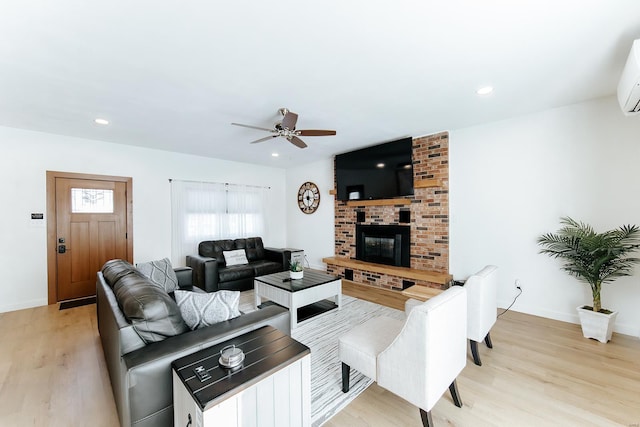 living area with light wood-type flooring, a brick fireplace, baseboards, and recessed lighting