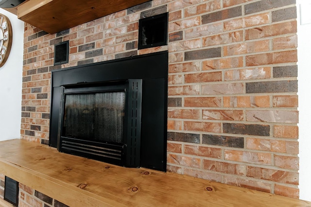 details with a brick fireplace and visible vents