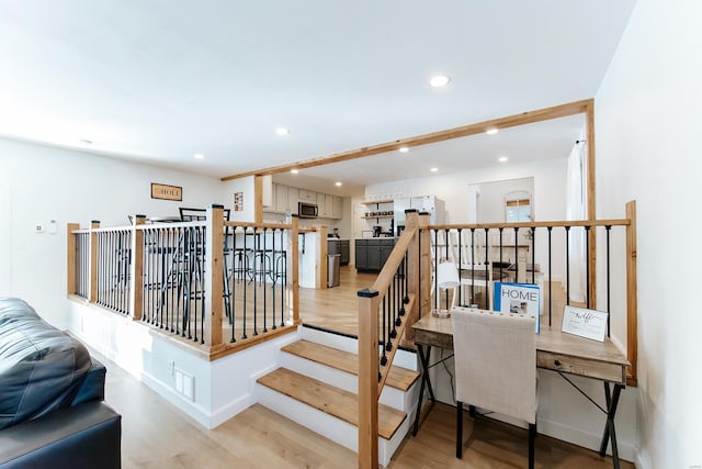 staircase with recessed lighting, baseboards, and wood finished floors