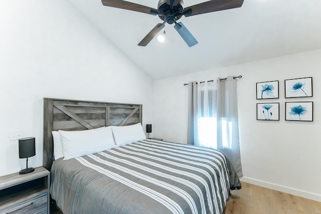 bedroom with vaulted ceiling, ceiling fan, wood finished floors, and baseboards