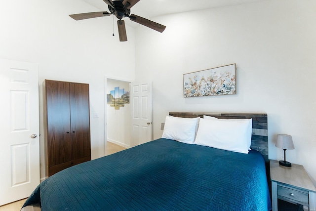 bedroom with ceiling fan and a towering ceiling