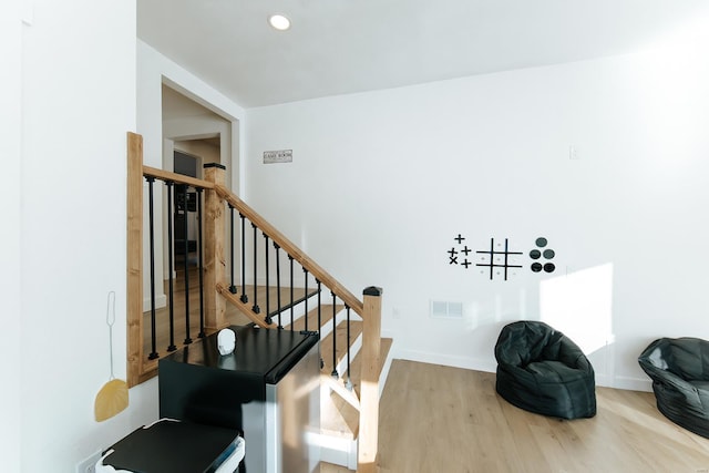 stairway with recessed lighting, wood finished floors, visible vents, and baseboards