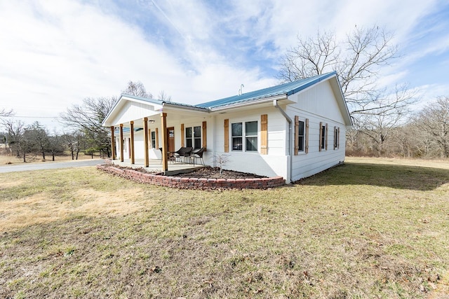 exterior space featuring a porch, metal roof, and a yard